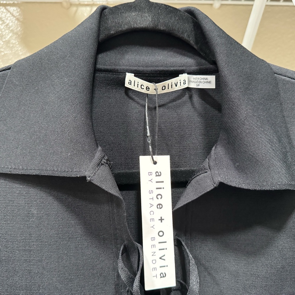 Women’s beautiful black dress, fits to body, shows cleavage.